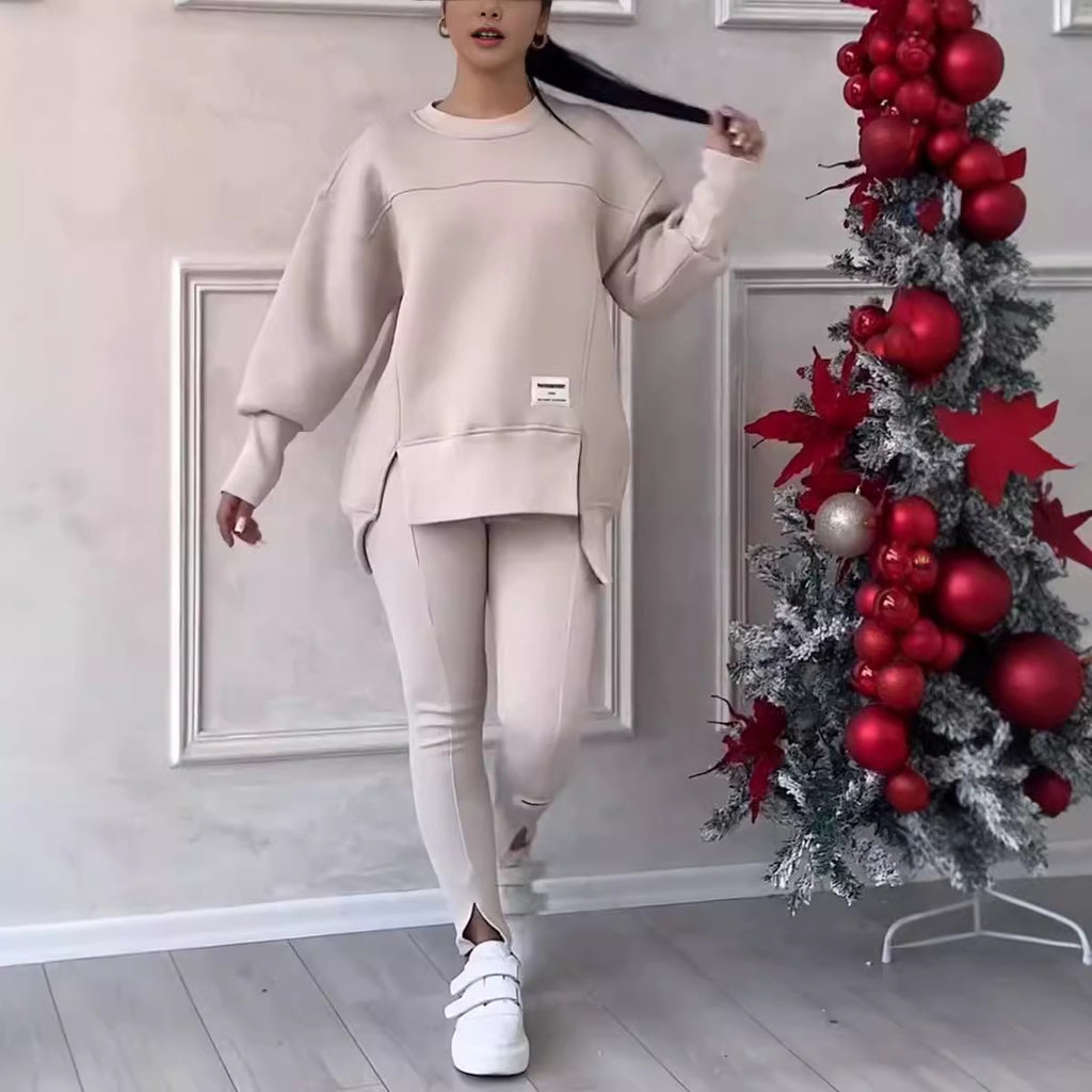 Long-sleeved beige printed sweater paired with matching leggings, featuring side slits and worn with white sneakers.