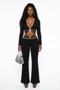 Black high-waist flared pants featuring tummy-control and butt-lifting design, paired with a fitted black top and handbag.