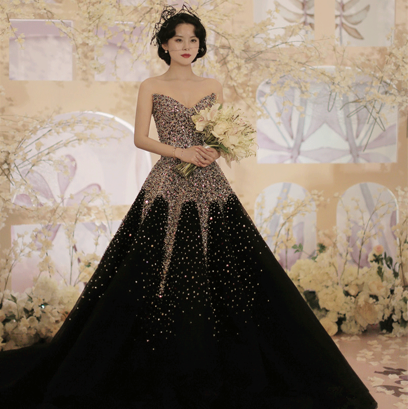 Deep V-neck black wedding gown adorned with crystal beads, fitted bodice, and a dramatic big train cascading to the floor.